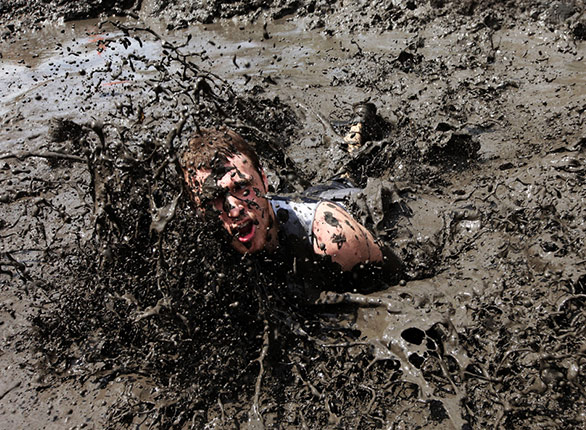 Man falling in the mud with a funny look on his face